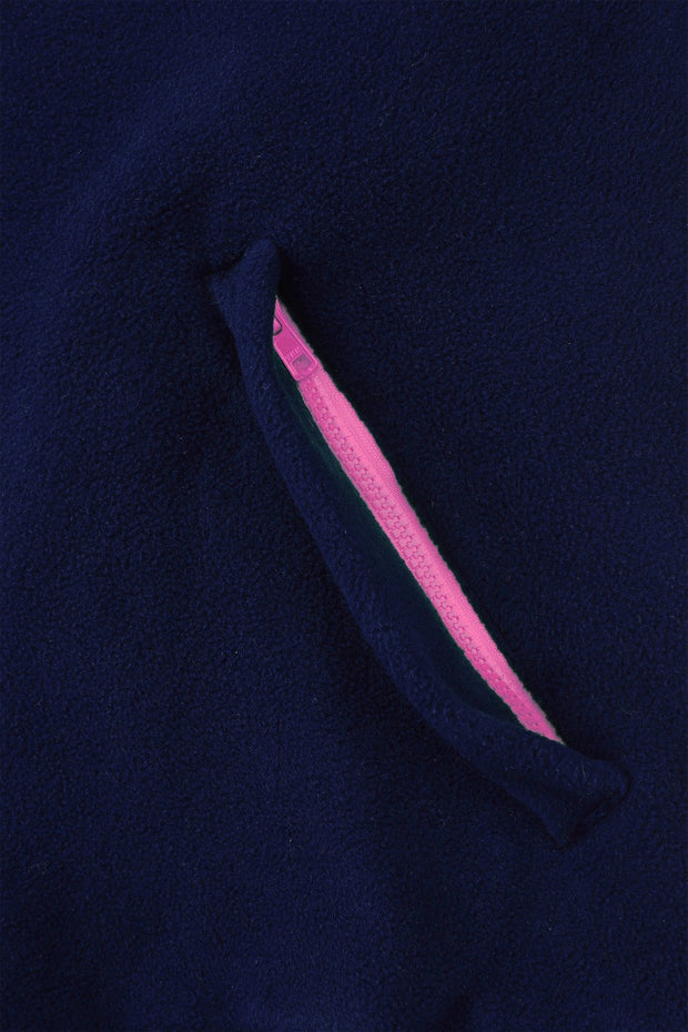 pocket detail close up image of nattily dressed navy blue fleece quarter zip with bright pink trim