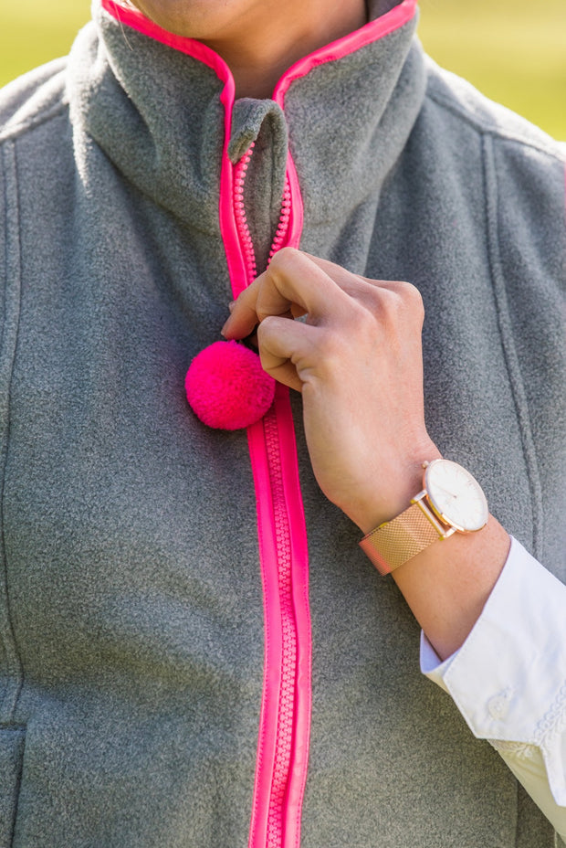 close up of zip and pompom on ladies grey fleece gilet with bright pink trim