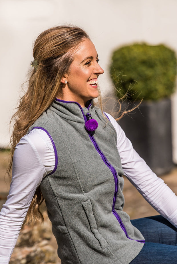 seated model wearing ladies grey fleece gilet with purple trim