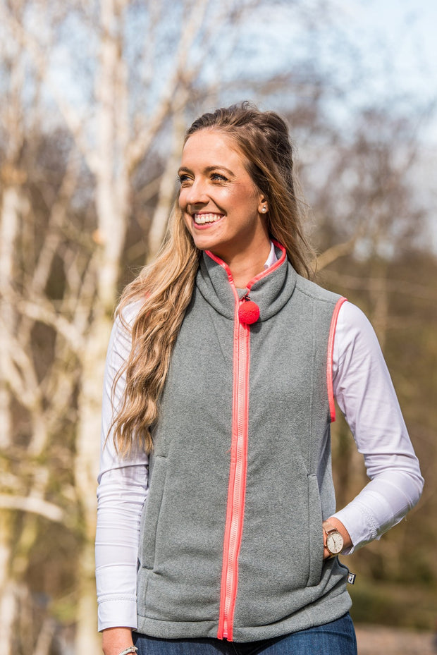 female model smiling wearing ladies grey fleece gilet with coral trim nattily dressed