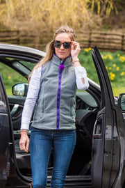 model in sunglasses wearing ladies grey fleece gilet with purple trim