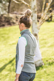model in garden wearing ladies grey fleece gilet with mint green trim