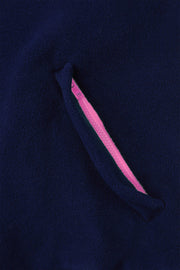 pocket detail close up image of nattily dressed navy blue fleece quarter zip with bright pink trim